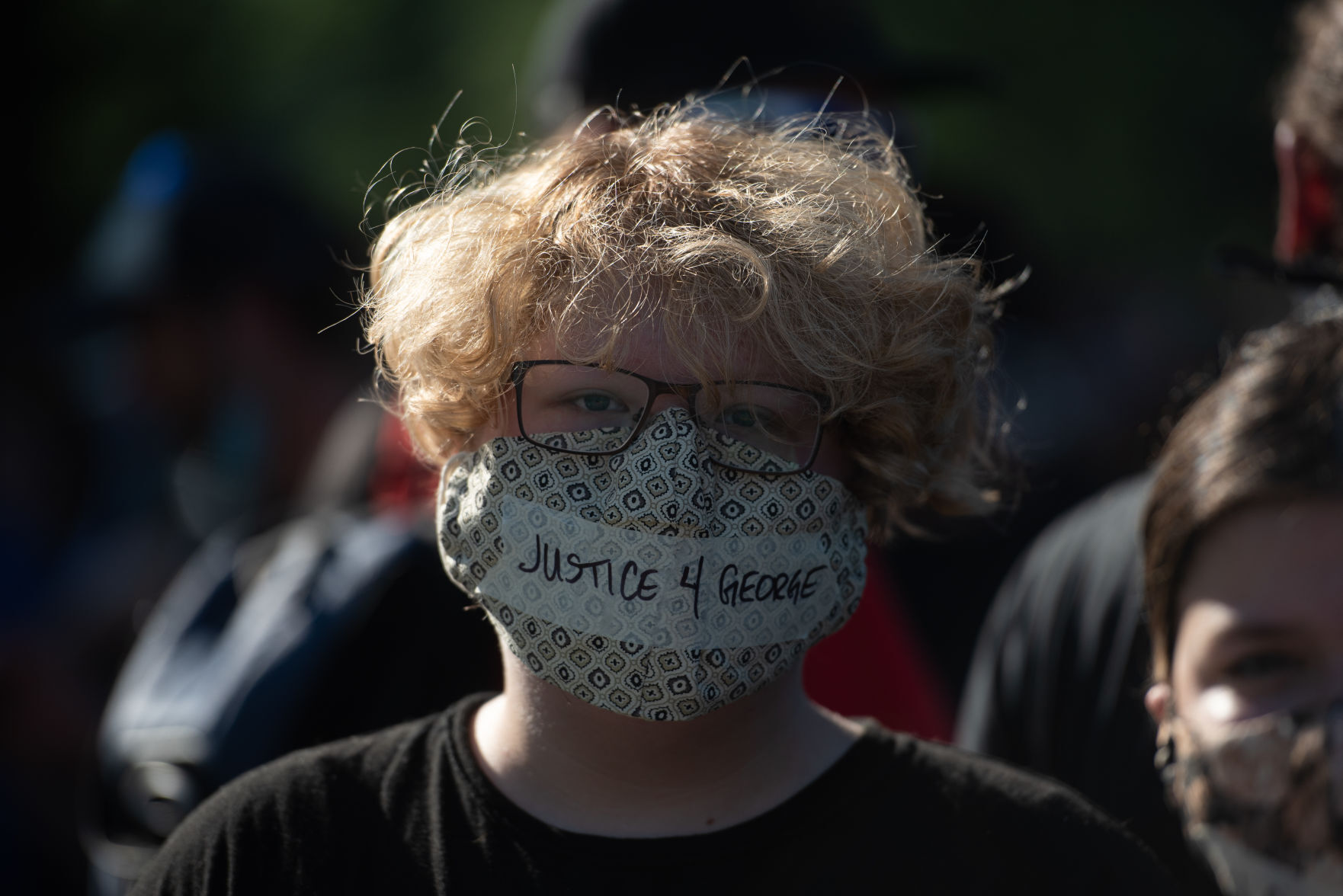 Amaya Cadue wears a mask that reads, ÒJustice 4 George,Ó during the peaceful protest in City Park on Wednesday.